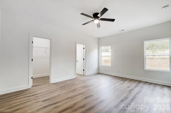 an empty room with wooden floor and windows