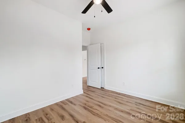 an empty room with ceiling fan and window