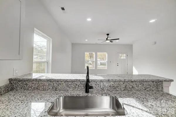 a kitchen with kitchen island a sink stainless steel appliances and window