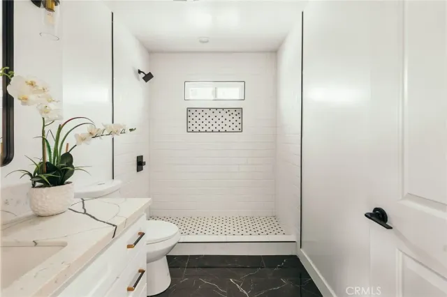 a kitchen with stainless steel appliances a white stove top oven a sink a counter space and cabinets