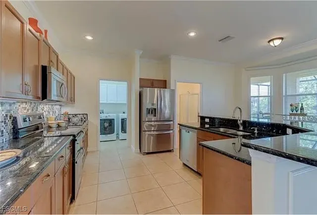 a kitchen with a sink a stove top oven and refrigerator