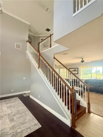 a view of staircase with lots of frames on wall and a window