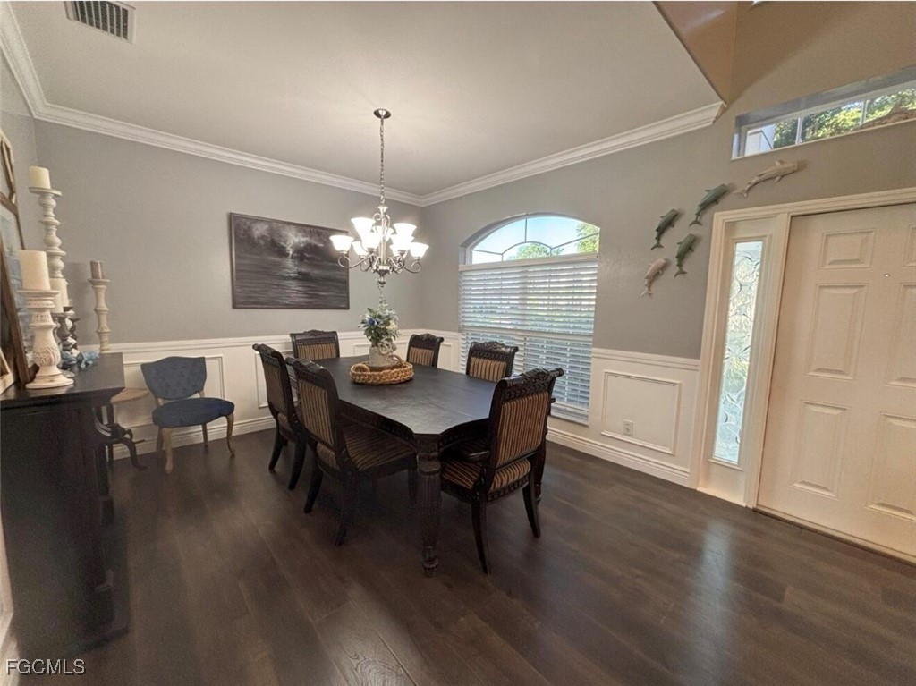 4577 Fairloop Run Lehigh Acres, FL 33973 - Photo 23 of 35 a view of a dining room with furniture a chandelier and wooden floor