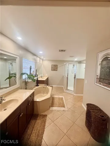 a large bathroom with a double vanity sink a mirror and a bathtub