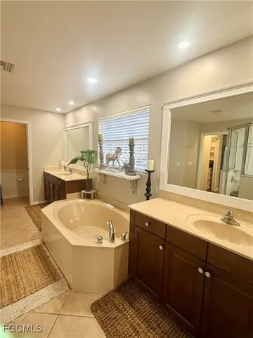 a large bathroom with a large tub and sink