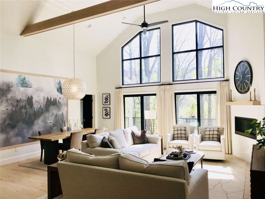 509 Crystal Mountain Road Boone, NC 28607 - Photo 6 of 24 a living room with furniture a fireplace and a floor to ceiling window