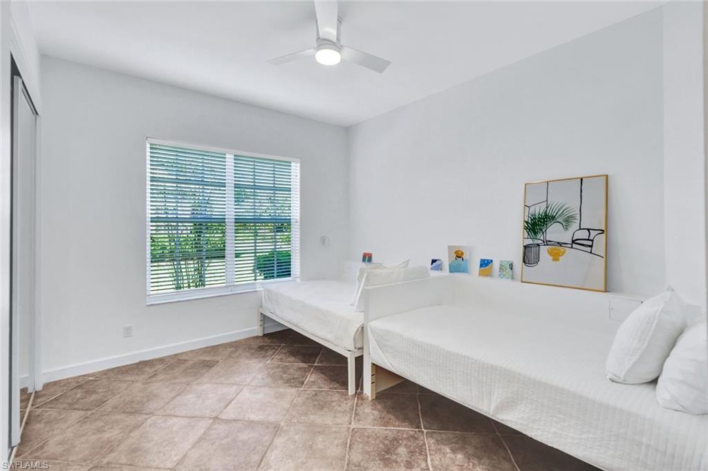 874 Wyndemere Way Naples, FL 34105 - Photo 21 of 32 a white bed sitting in a bedroom next to a window
