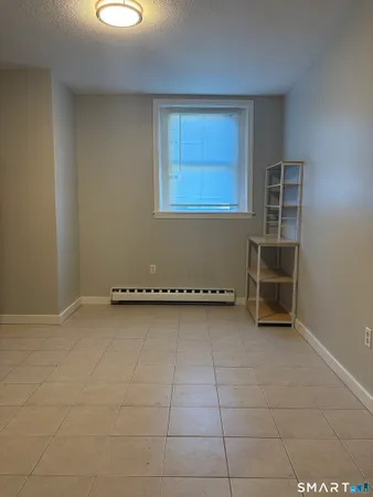 a view of a storage & utility room with refrigerator