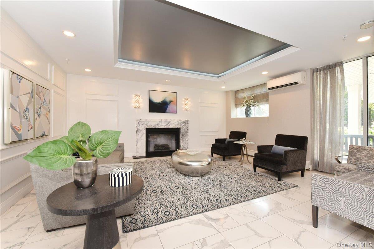 320 East Shore Road, Unit 2A Great Neck, NY 11023 - Photo 6 of 28 a living room with furniture a fireplace and a large window