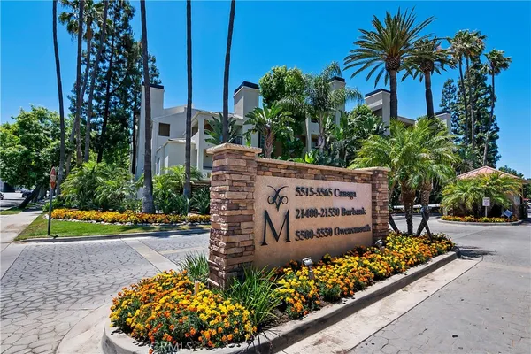 a sign that is sitting in front of flowers