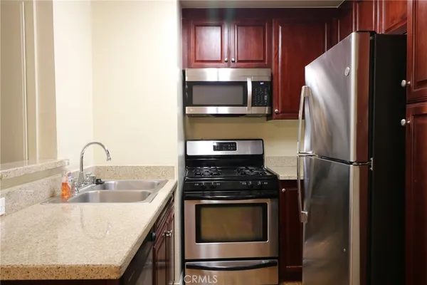 a kitchen with stainless steel appliances granite countertop a refrigerator stove and sink