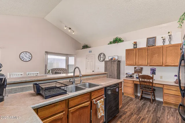 a kitchen with stainless steel appliances granite countertop a refrigerator a stove and a sink with wooden floor