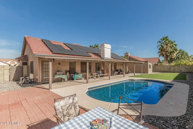 a view of a house with swimming pool and sitting area