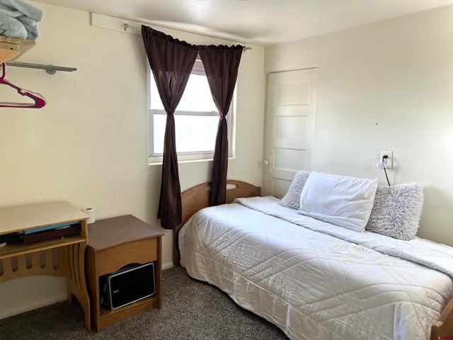 a bedroom with a bed next to a window