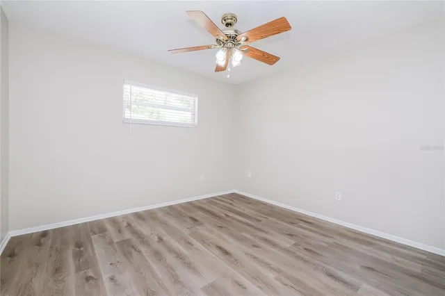 an empty room with a window and a fan