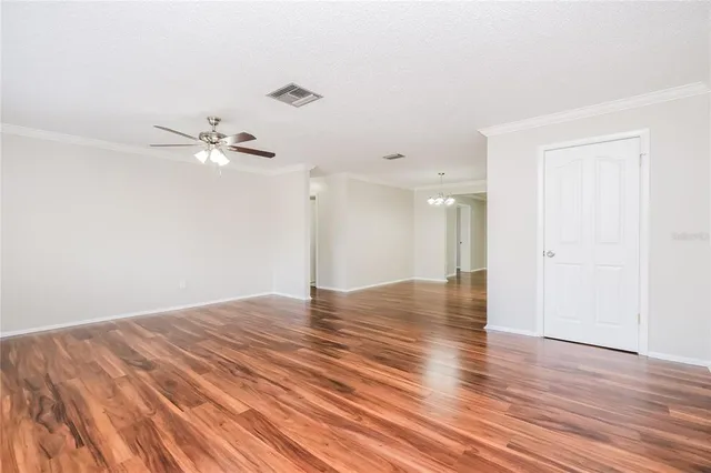 wooden floor in an empty room with a chandelier