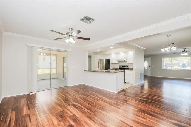 a view of an empty room with window and wooden floor