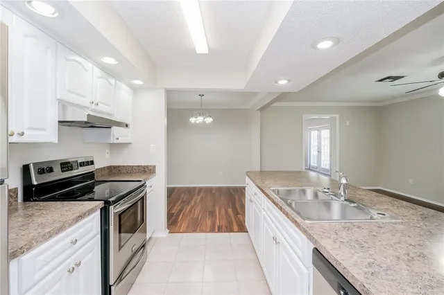 a kitchen that has a sink a stove and cabinets