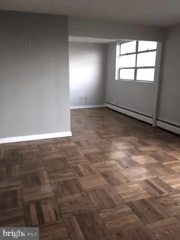 an empty room with wooden floor and sliding door