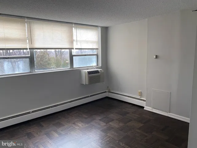 a view of empty room with wooden floor and closet