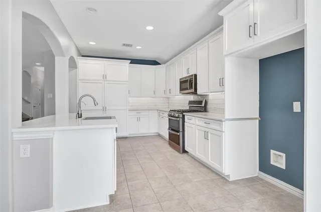a kitchen with appliances a sink and cabinets