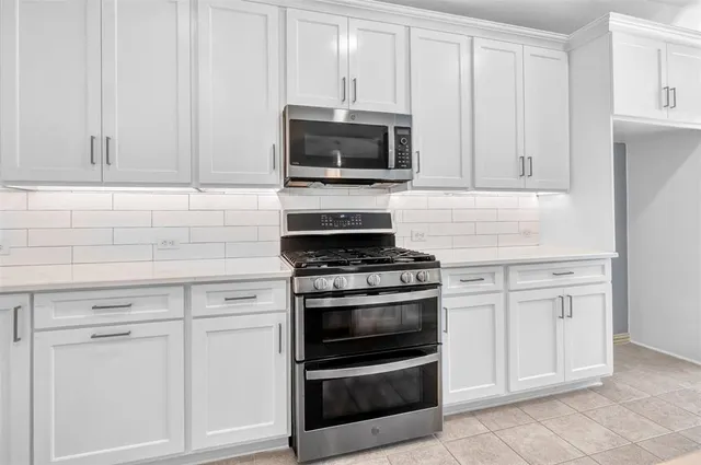 a kitchen with white cabinets and stainless steel appliances