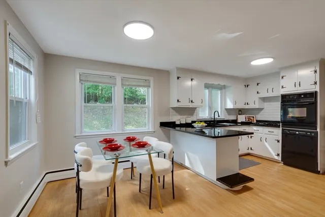 a kitchen with stainless steel appliances kitchen island granite countertop a stove a sink a refrigerator dining table and chairs