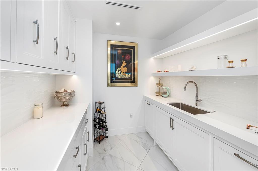 13945 Old Coast Road, Unit 806 Naples, FL 34110 - Photo 9 of 50 a kitchen with a sink and cabinets