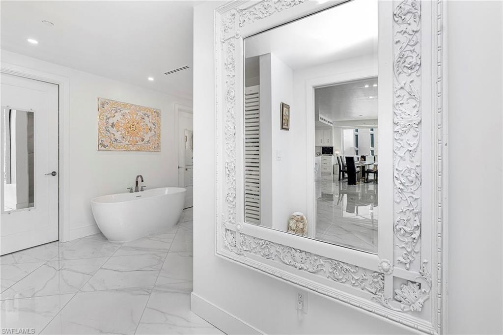 13945 Old Coast Road, Unit 806 Naples, FL 34110 - Photo 12 of 50 a bathroom with a bathtub and mirror