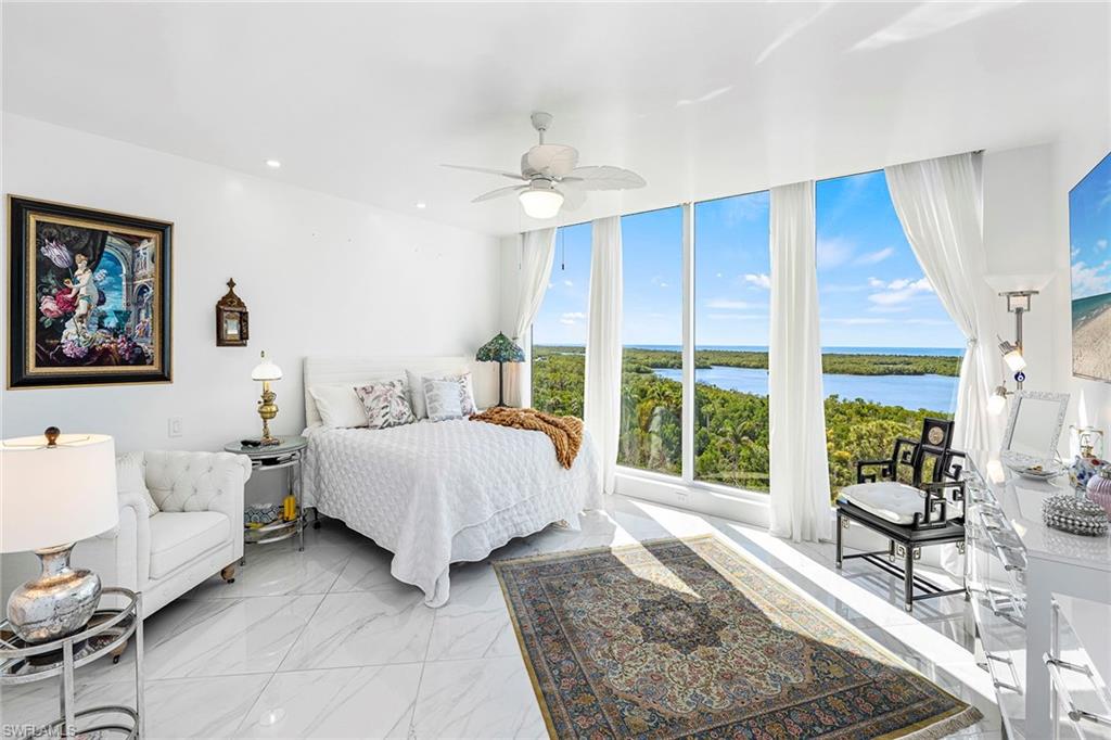 13945 Old Coast Road, Unit 806 Naples, FL 34110 - Photo 13 of 50 a spacious bedroom with a bed a table and chair