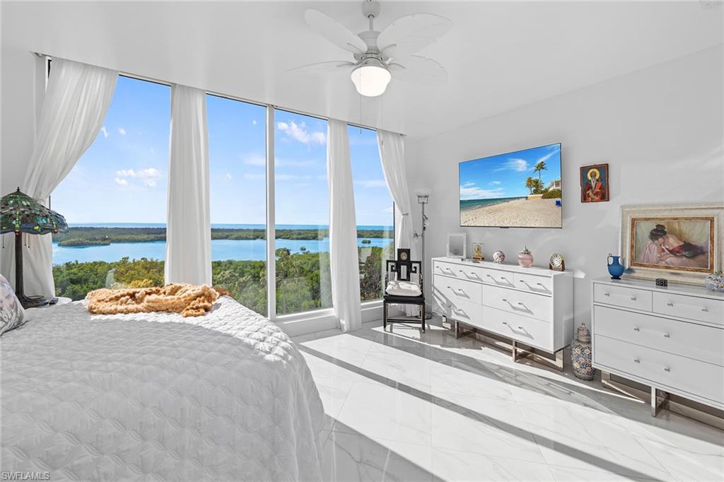 13945 Old Coast Road, Unit 806 Naples, FL 34110 - Photo 15 of 50 a room with a bed and large windows