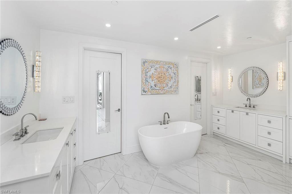 13945 Old Coast Road, Unit 806 Naples, FL 34110 - Photo 16 of 50 a bathroom with a double vanity sink mirror and bathtub