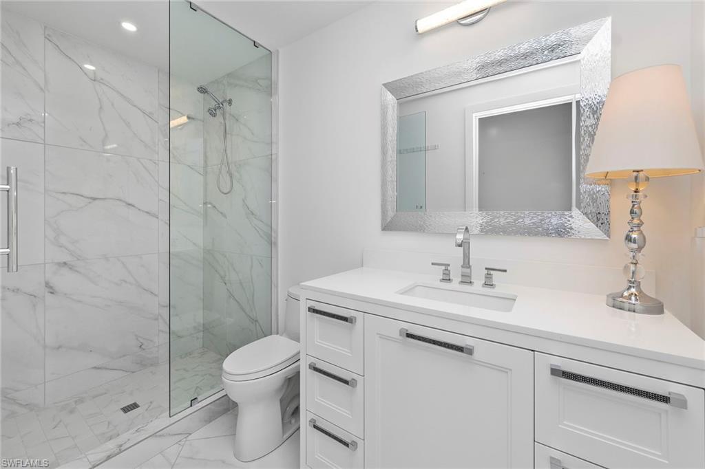 13945 Old Coast Road, Unit 806 Naples, FL 34110 - Photo 22 of 50 a bathroom with a sink toilet a mirror and shower