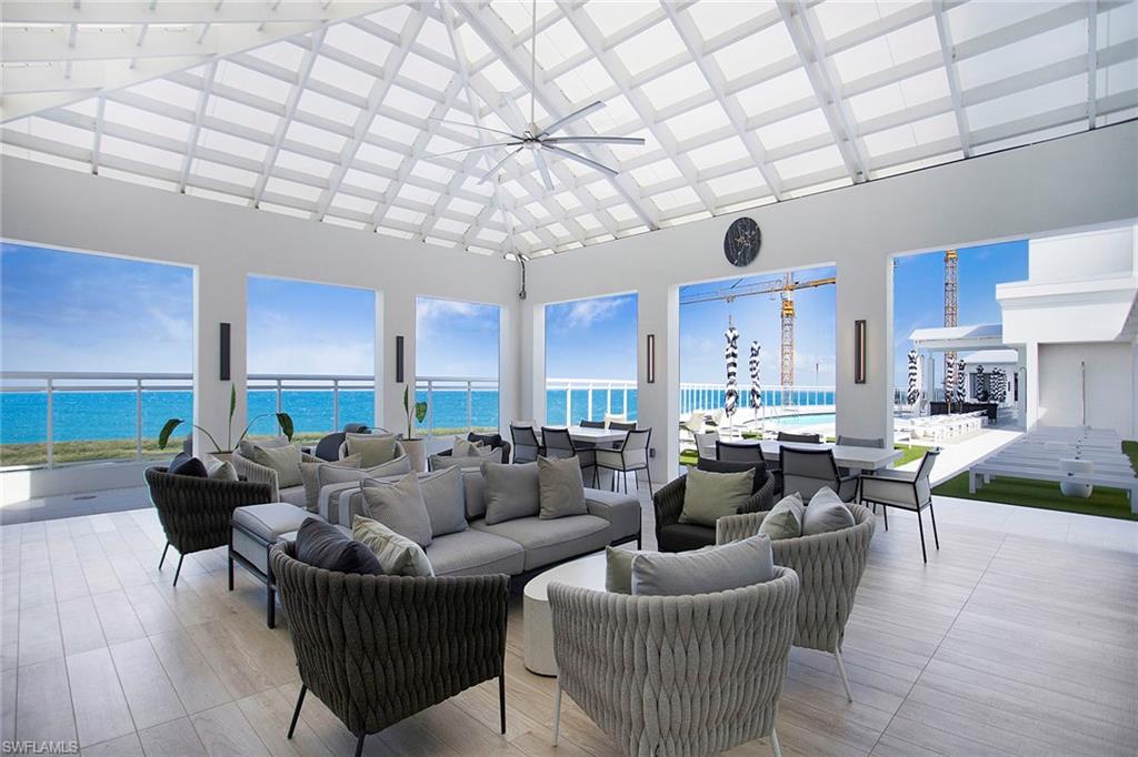 13945 Old Coast Road, Unit 806 Naples, FL 34110 - Photo 39 of 50 a living room with furniture a large window and a chandelier