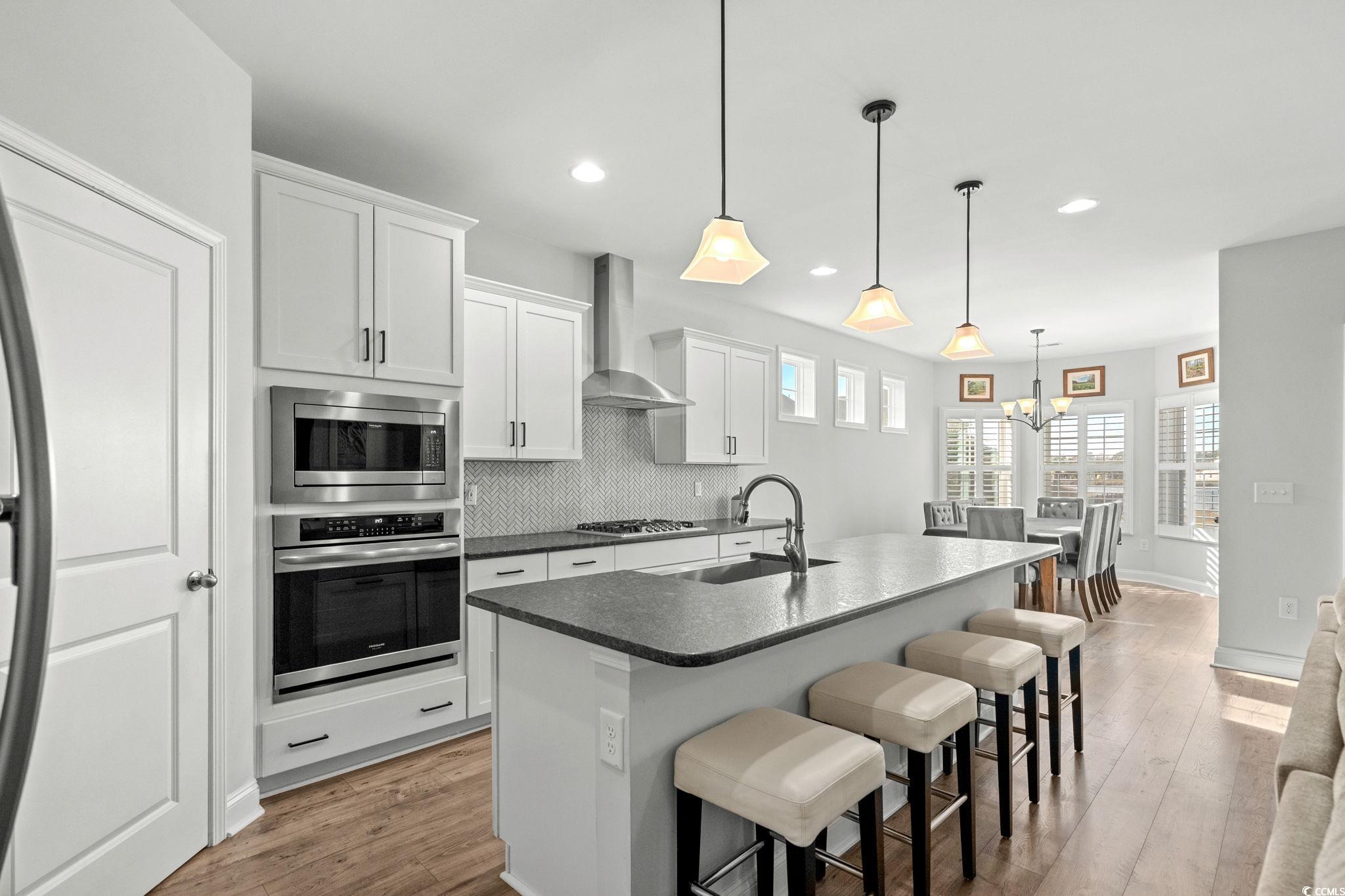 506 Indigo Bay Circle Myrtle Beach, SC 29579 - Photo 12 of 40 Kitchen with stainless steel appliances, a kitchen breakfast bar, pendant lighting, light wood finished floors, and recessed lighting