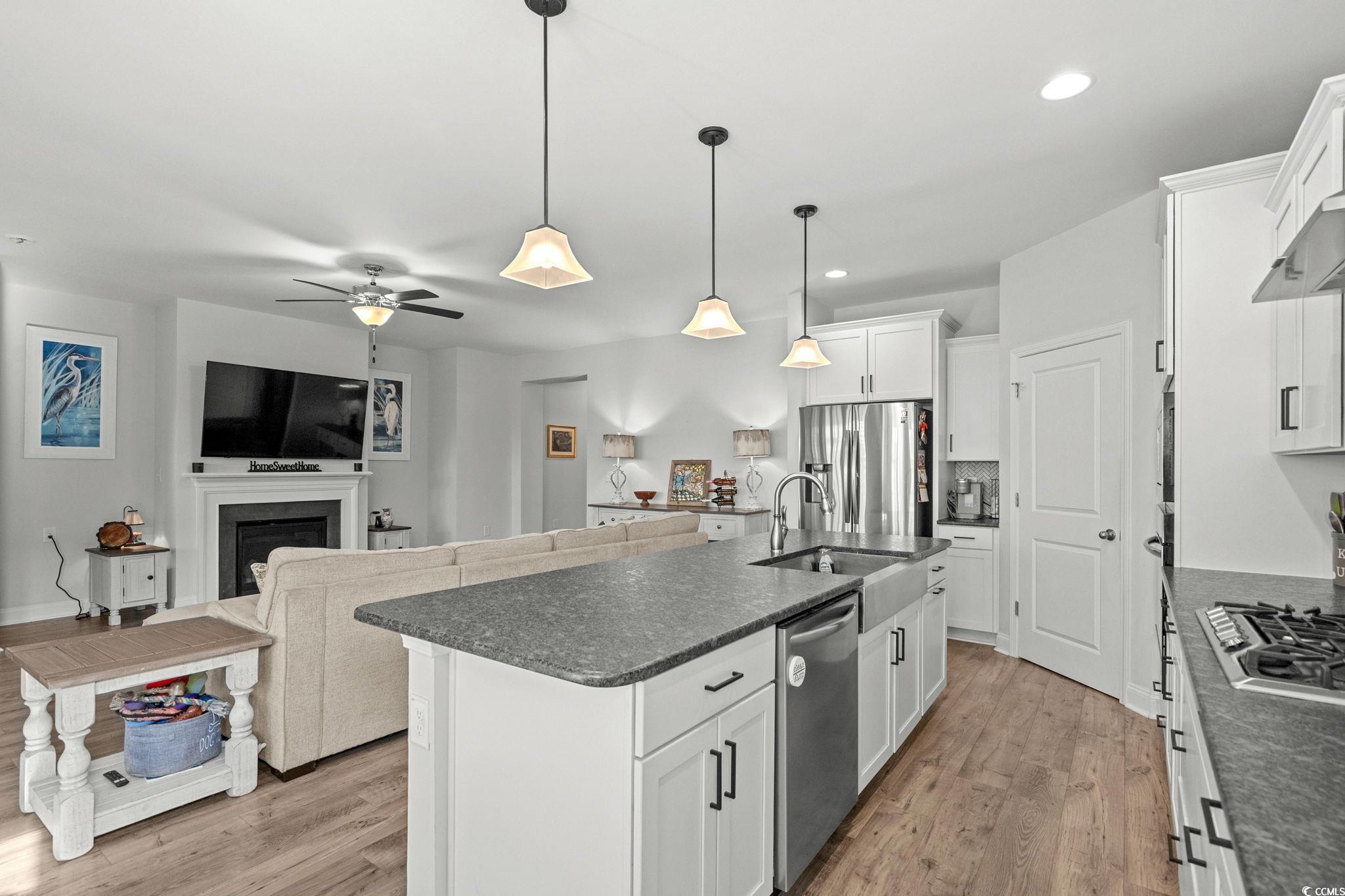 506 Indigo Bay Circle Myrtle Beach, SC 29579 - Photo 14 of 40 Kitchen with white cabinetry, decorative light fixtures, ceiling fan, a kitchen island with sink, and stainless steel appliances