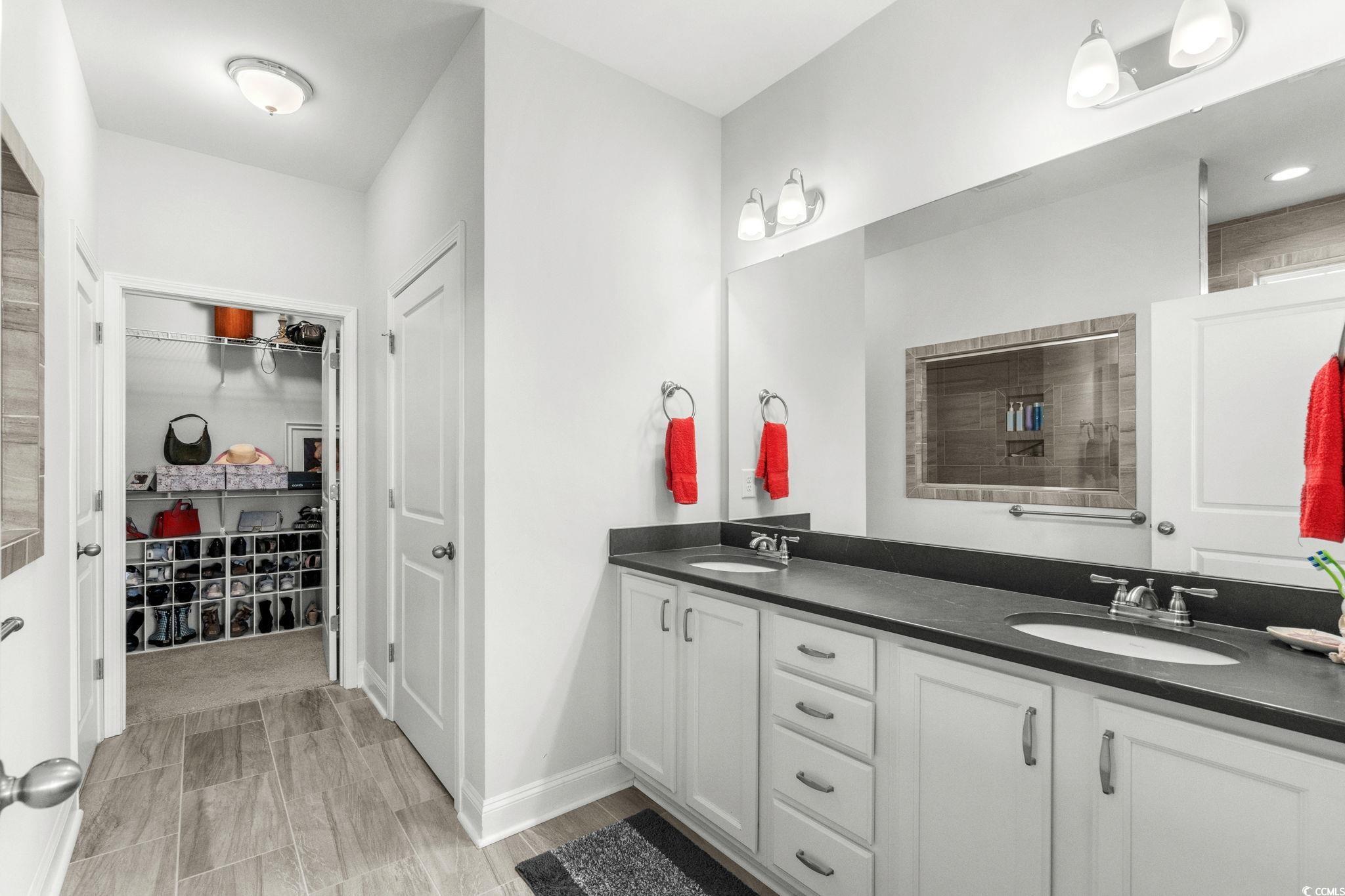 506 Indigo Bay Circle Myrtle Beach, SC 29579 - Photo 24 of 40 Full bathroom featuring double vanity, a walk in closet, and tiled shower