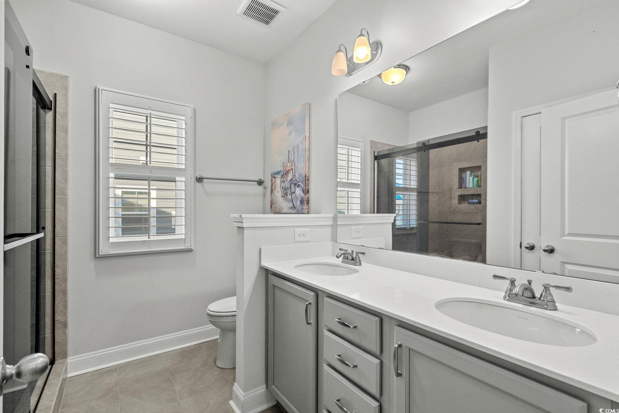 506 Indigo Bay Circle Myrtle Beach, SC 29579 - Photo 28 of 40 Bathroom featuring double vanity, a shower stall, and light tile patterned floors