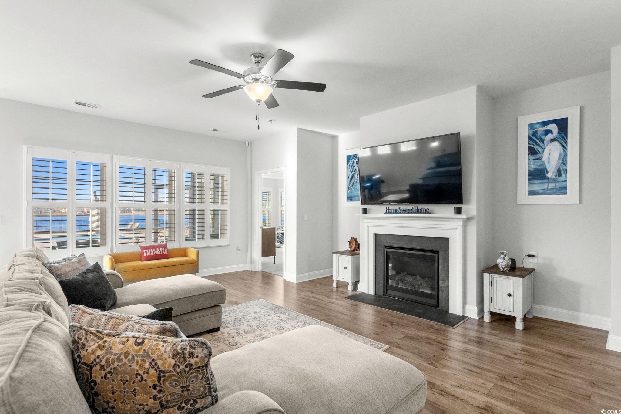 506 Indigo Bay Circle Myrtle Beach, SC 29579 - Photo 10 of 40 Living area with a glass covered fireplace, wood finished floors, and ceiling fan