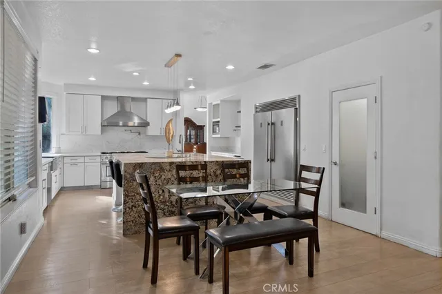 a kitchen with granite countertop a stove a sink and a refrigerator