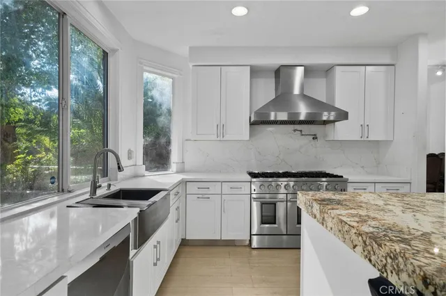 a kitchen with kitchen island granite countertop a sink and a stove