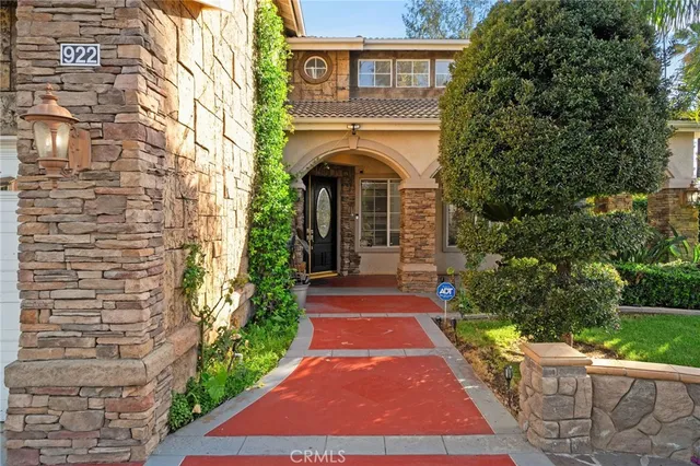 a front view of a house with garden and trees