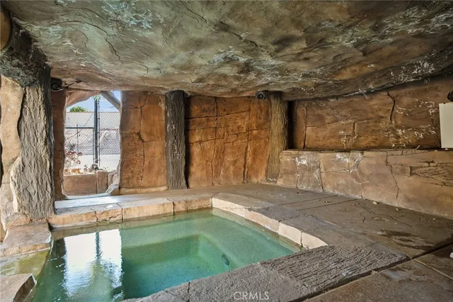 a row of palm trees and swimming pool in the backyard of a house