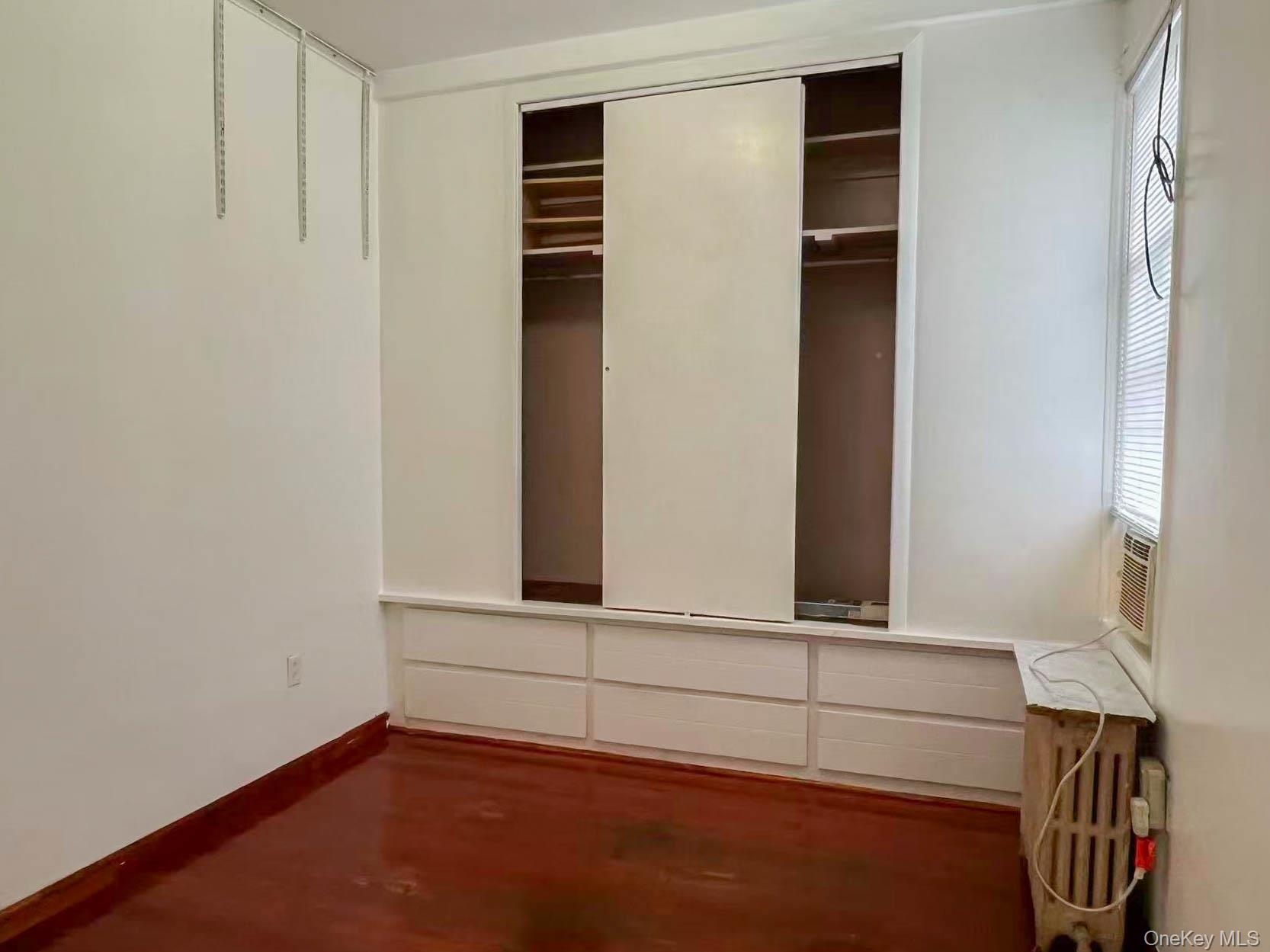 22-32 124th Street Queens, NY 11356 - Photo 3 of 8 Unfurnished bedroom featuring baseboards and a closet