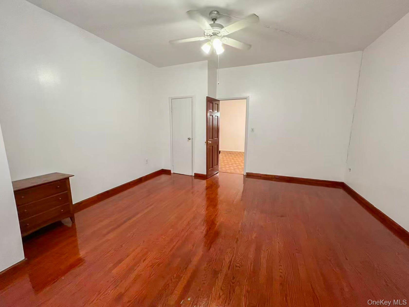 22-32 124th Street Queens, NY 11356 - Photo 6 of 8 Unfurnished room featuring wood finished floors and ceiling fan