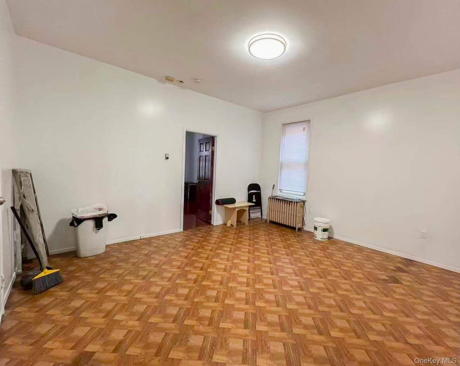 22-32 124th Street Queens, NY 11356 - Photo 7 of 8 Spare room with radiator and baseboards