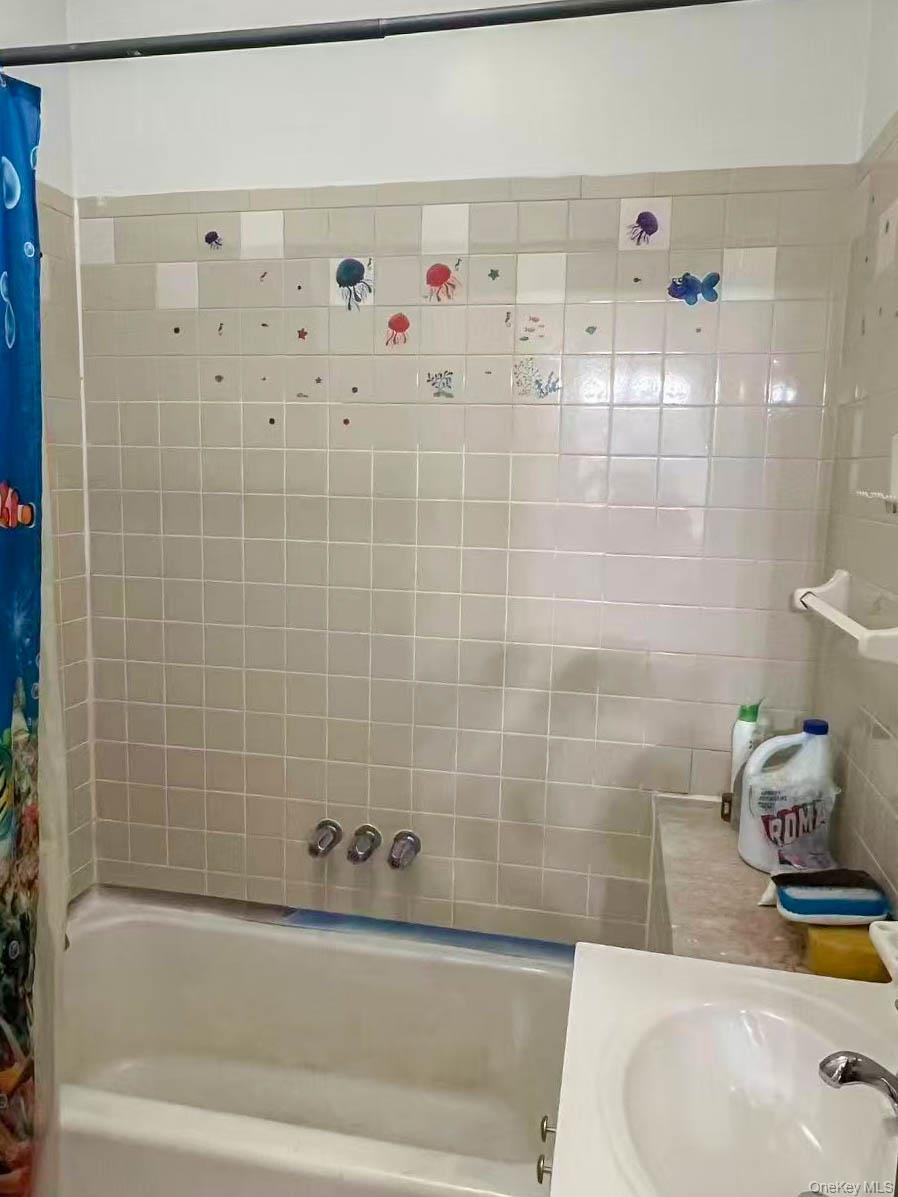 22-32 124th Street Queens, NY 11356 - Photo 8 of 8 Bathroom with shower / bath combination with curtain and vanity