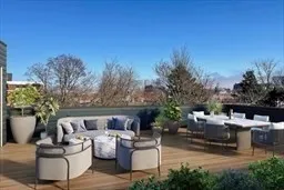 a view of a patio with couches and a table and chairs with wooden fence