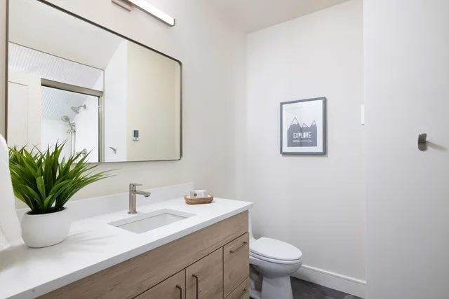 a bathroom with a sink a toilet and a mirror