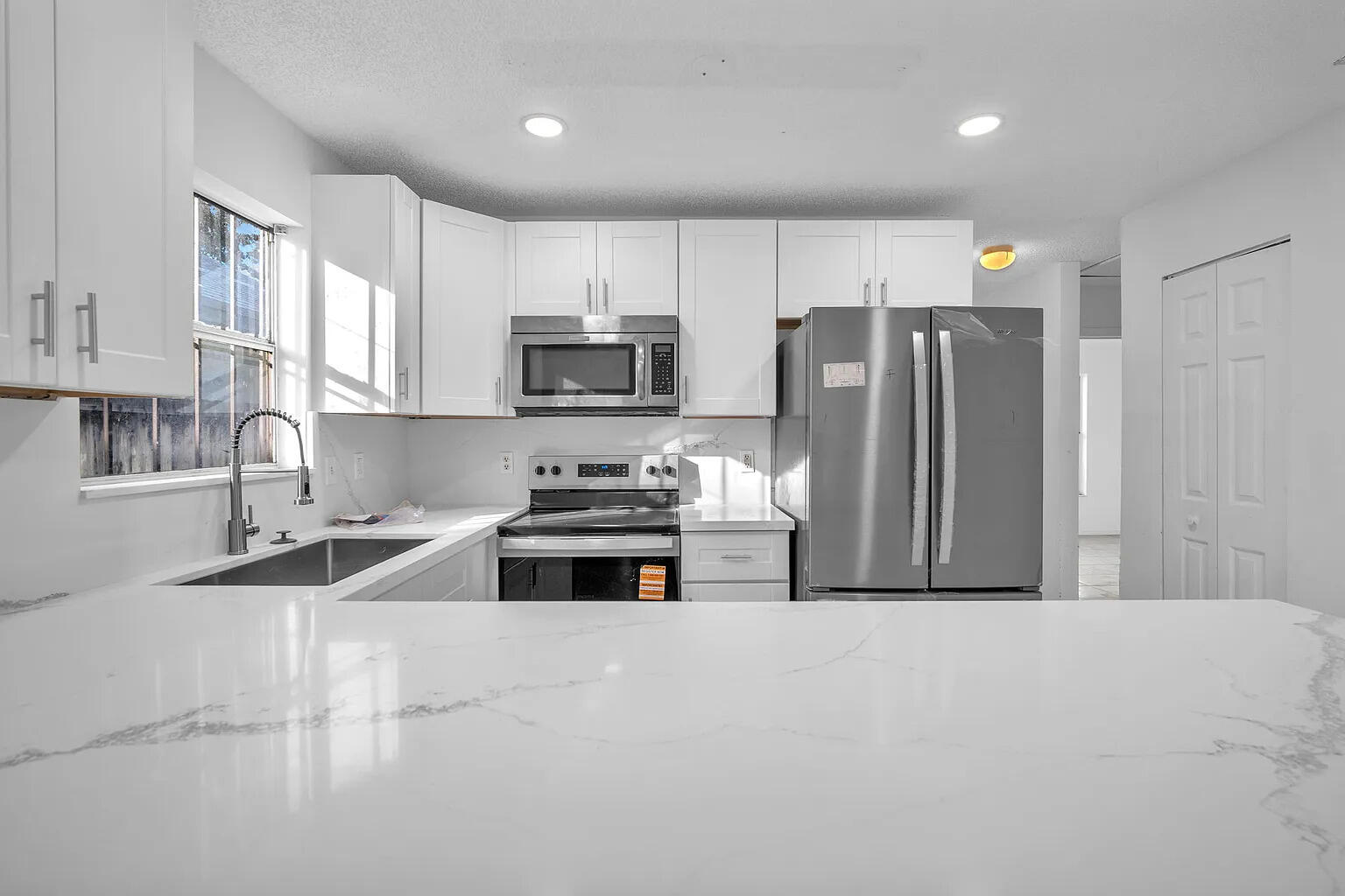 719 Southwest 10th Street Florida City, FL 33034 - Photo 3 of 13 a kitchen with stainless steel appliances a refrigerator sink and microwave